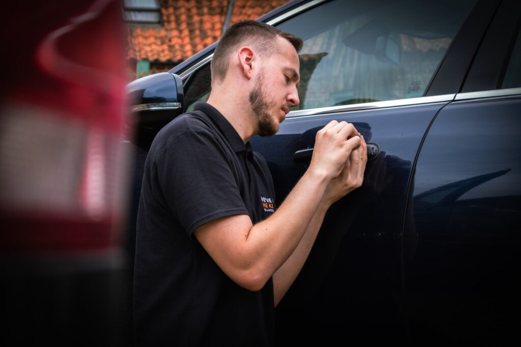An automotive locksmith opening a car door lock